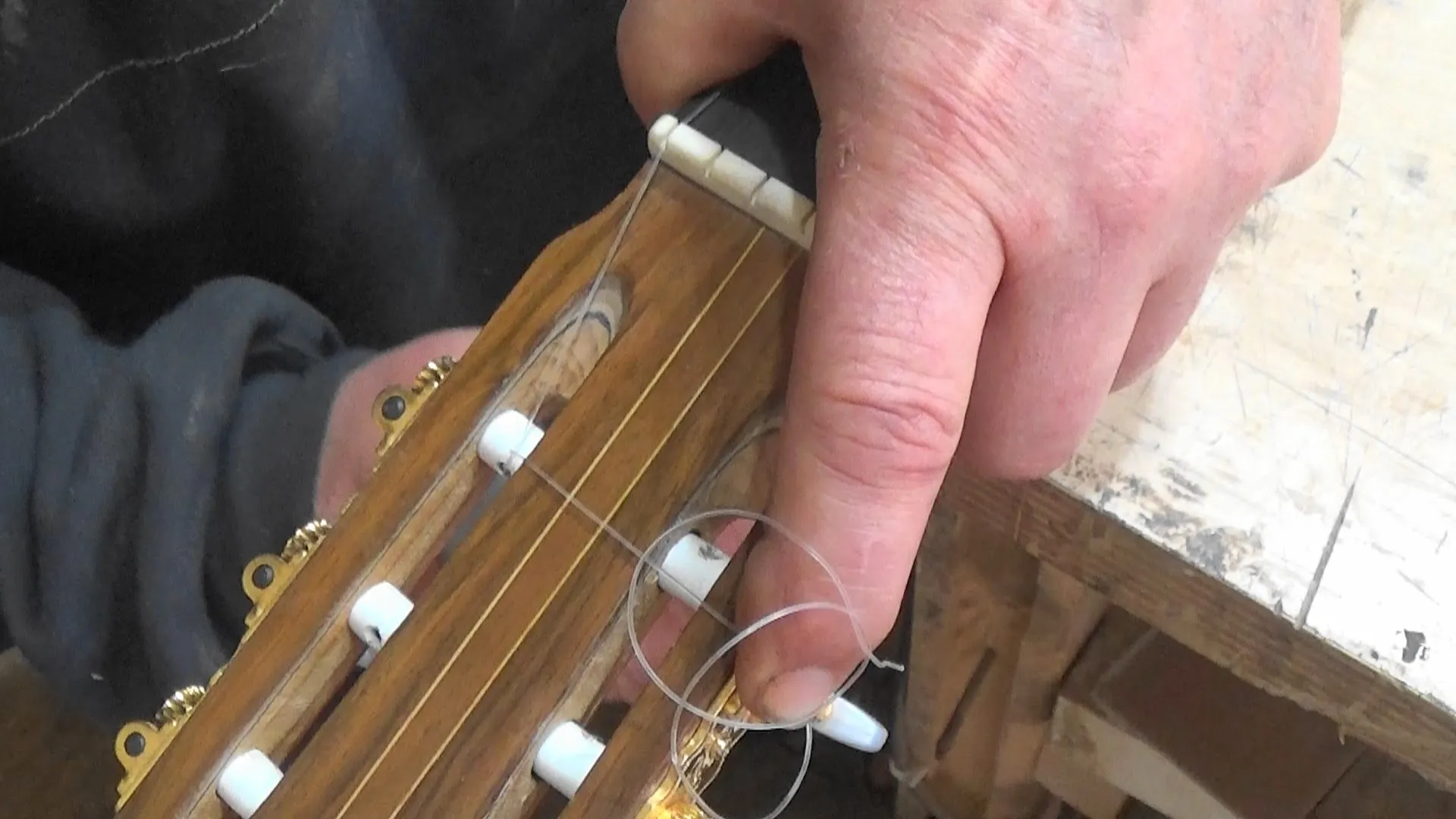 Encordoamento de violão mostrando enrolamento descendente das cordas nas tarraxas com técnica de lock-wrap