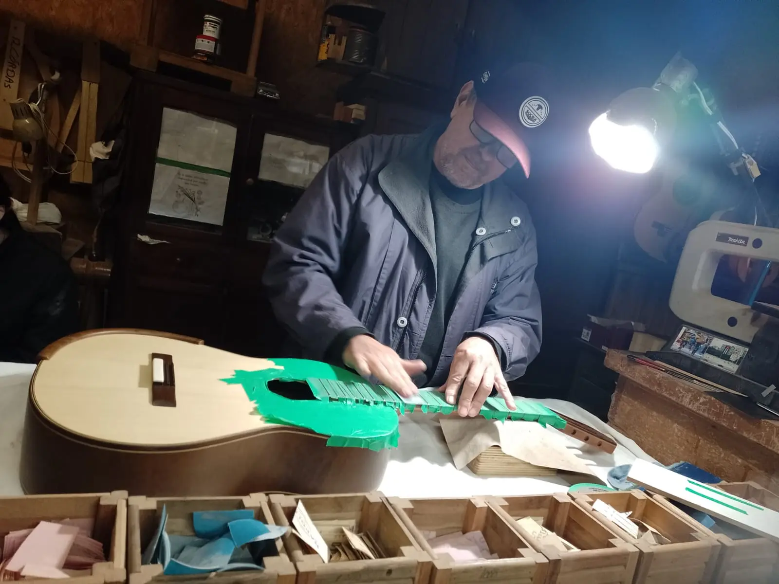 Peças de violão artesanal em diferentes etapas de construção sobre bancada de luthieria