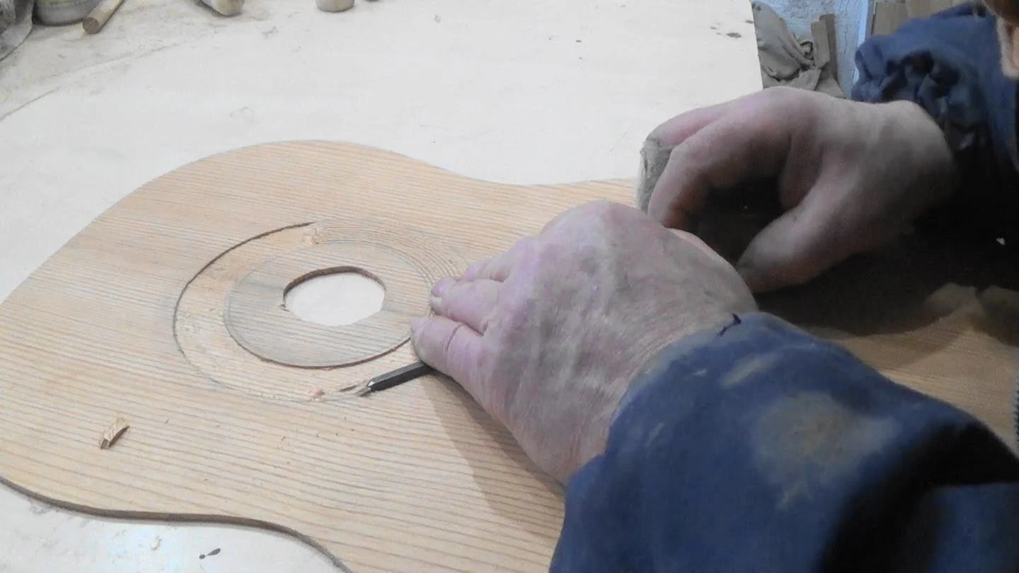 Canal da roseta do violão sendo aberto com precisão no tampo de madeira