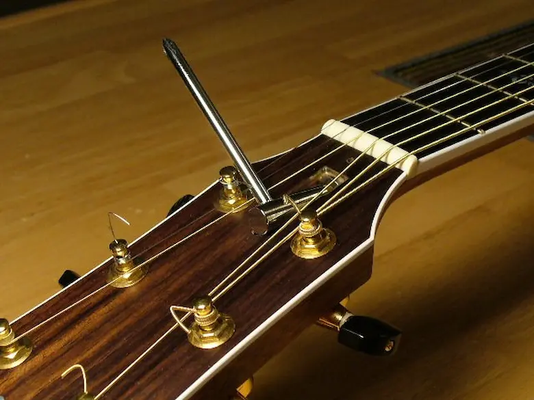 Tensor de dupla ação do violão sendo regulado