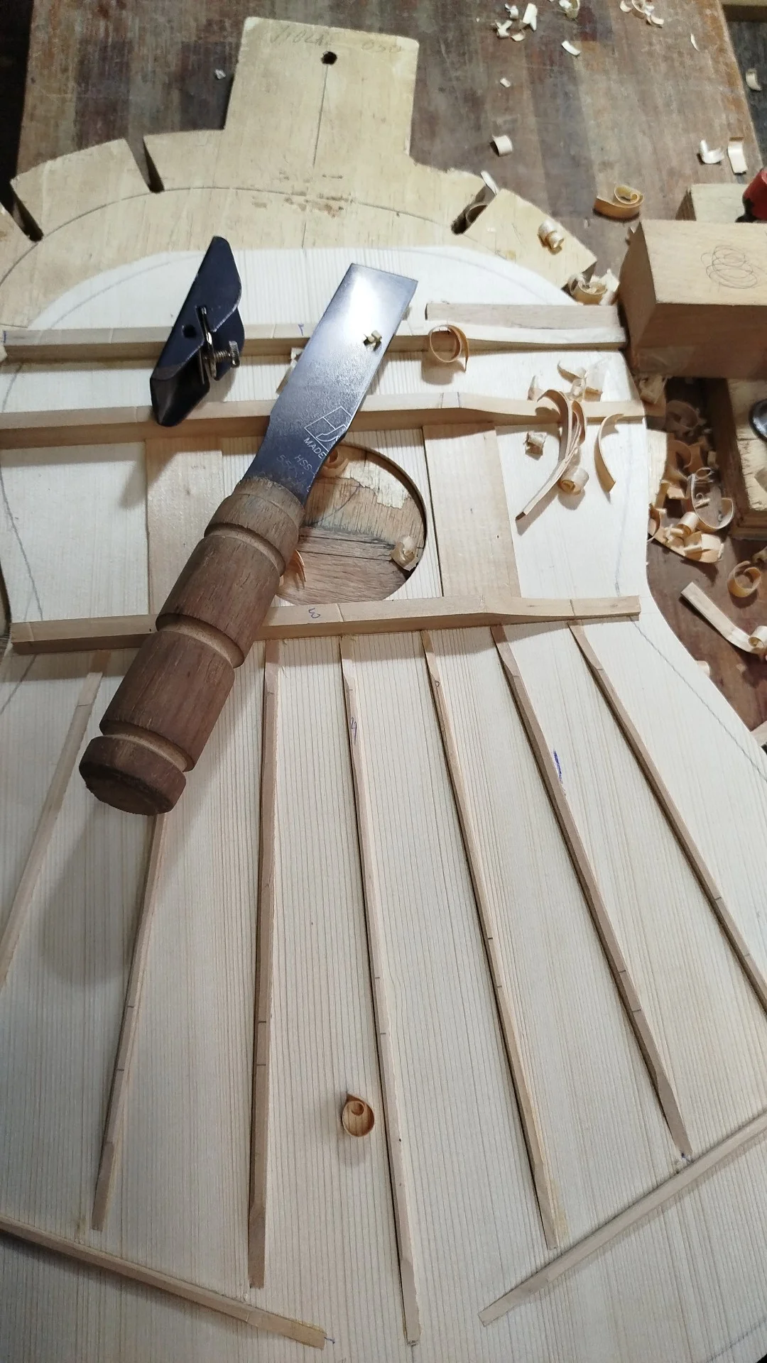 Ajuste das varetas do leque harmônico com formão durante o voicing do tampo